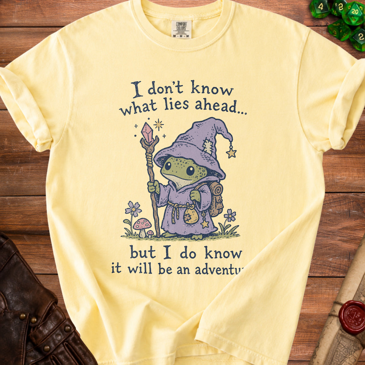 Yellow t-shirt with a wizard frog graphic and text: "I don't know what lies ahead... but I do know it will be an adventure."
