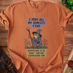 Orange t-shirt with frog wizard graphic and text: "I pray all my homies find whatever it is that they're searching for."