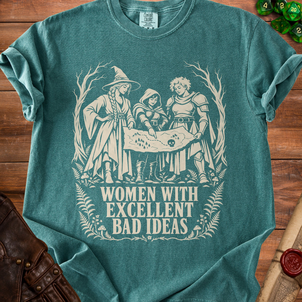 Teal t-shirt graphic with three women examining a map, text "WOMEN WITH EXCELLENT BAD IDEAS".