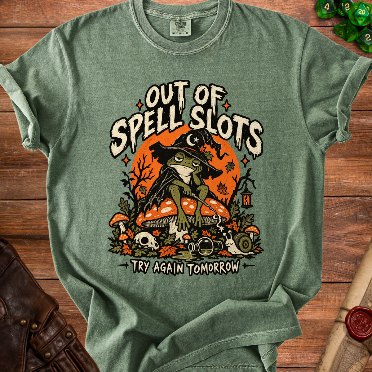 T-shirt with "Out of Spell Slots" text, featuring a sad frog wizard and fall elements.