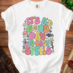 White t-shirt with "It's a good day to cast spells" text and whimsical graphics.