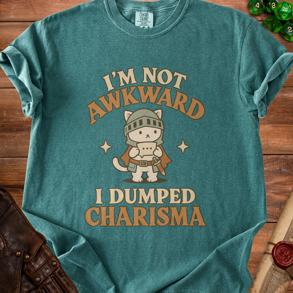 Teal t-shirt with a cat knight graphic and text "I'm not awkward, I dumped Charisma."