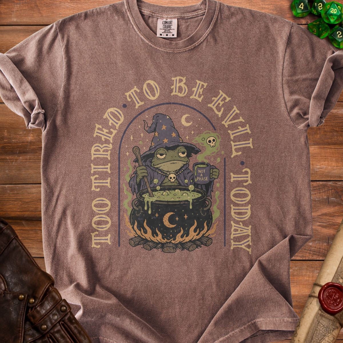 Brown t-shirt with a graphic of a tired frog wizard and text "Too Tired to Be Evil Today".