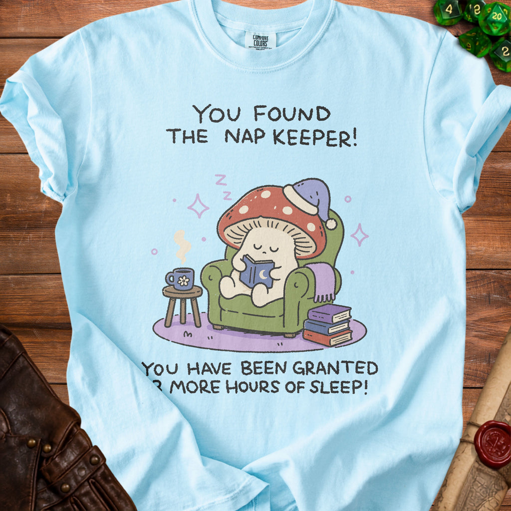 Light blue t-shirt with a graphic of a mushroom wearing a sleep cap reading, text says "You found the nap keeper! You have been granted 3 more hours of sleep!".