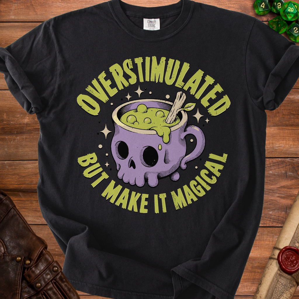 Black t-shirt with text "OVERSTIMULATED BUT MAKE IT MAGICAL" and skull cauldron graphic.