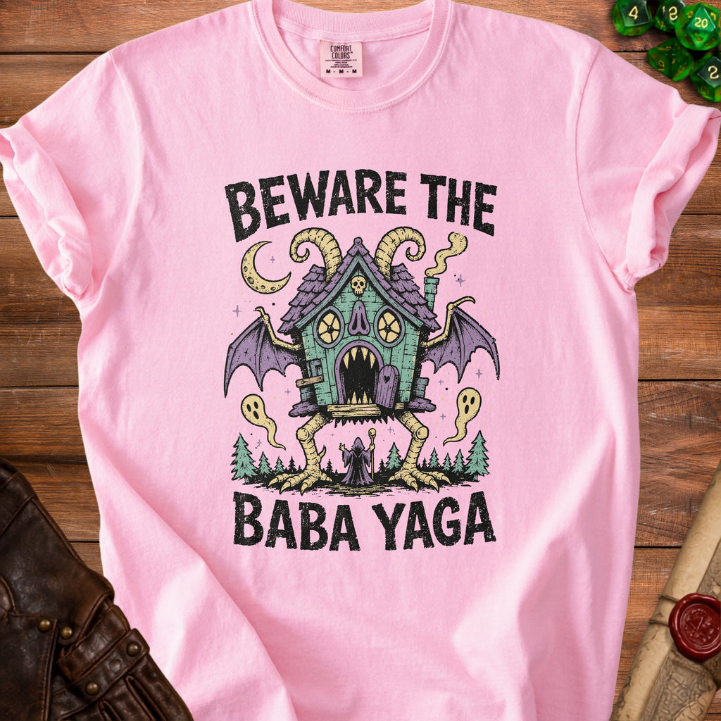 Pink t-shirt with a Baba Yaga house illustration and text.