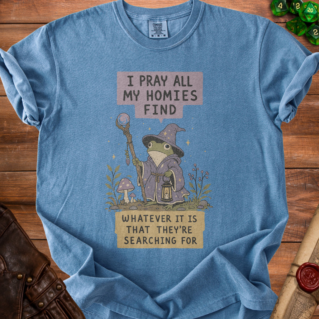 Blue t-shirt with frog wizard graphic and text "I pray all my homies find whatever it is that they're searching for".