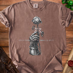 Brown t-shirt with graphic of gauntlet holding rose and text "HELD TOGETHER BY BOWS & SPITE".