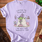 T-shirt with illustration of a green, anxious character in a wizard hat, text says "Listen to Your Gut".