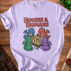 T-shirt with four cartoon dragons playing a tabletop game with houses and people.