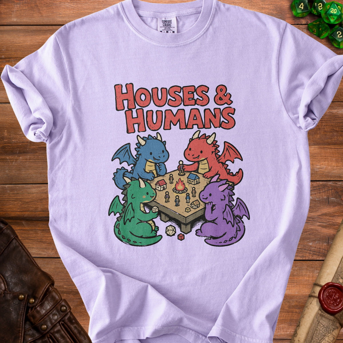T-shirt with four cartoon dragons playing a tabletop game with houses and people.