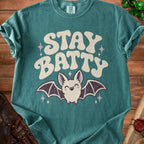 Teal t-shirt with "STAY BATTY" text and a smiling bat graphic.