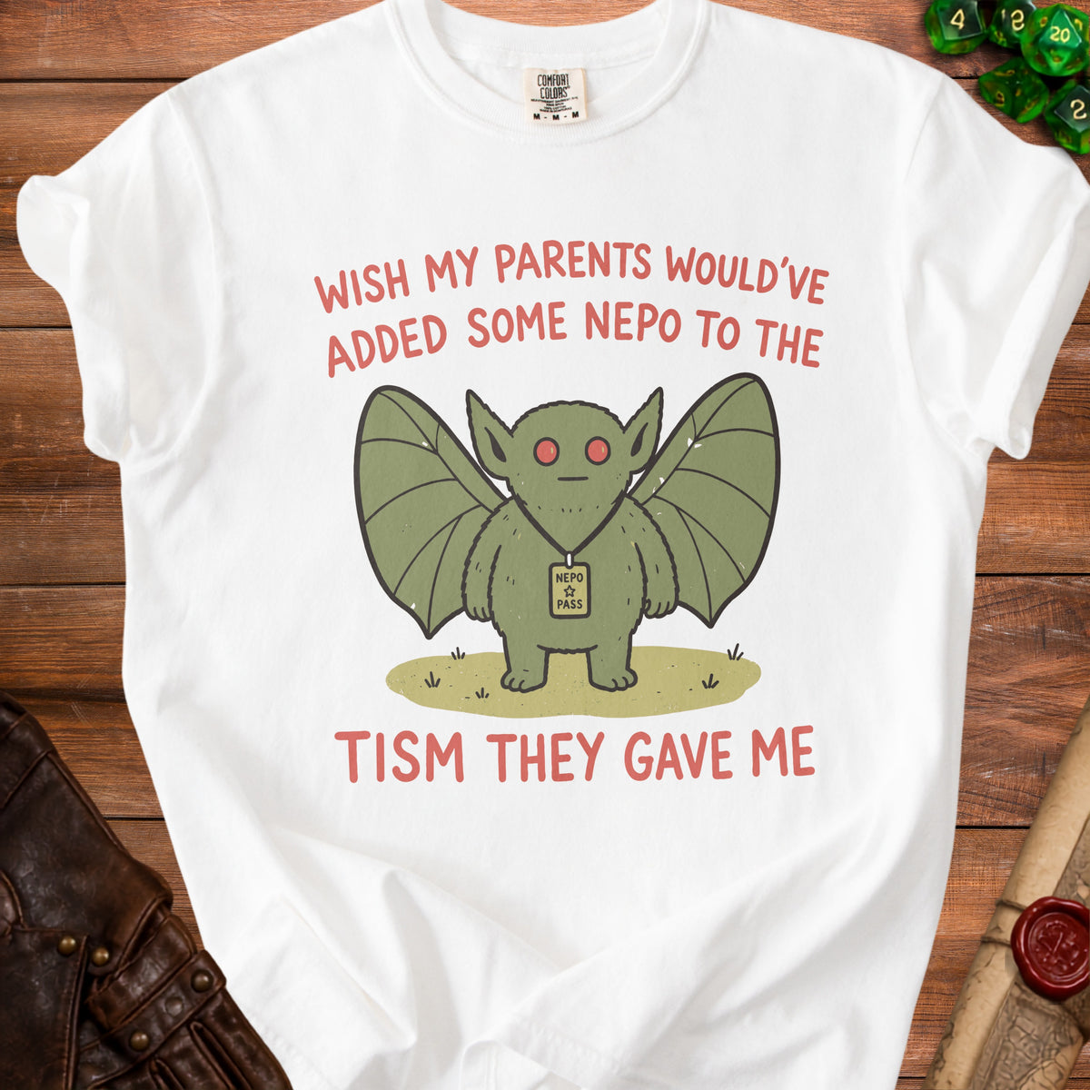 White t-shirt with a green creature graphic and text saying "Wish my parents would've added some nepo to the nepotism they gave me."