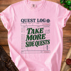 Pink t-shirt with "Quest Log" graphic featuring "Take More Side Quests".