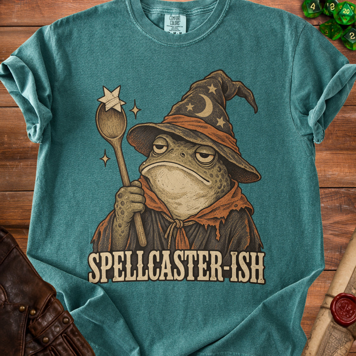 Teal t-shirt with a frog wizard holding a star-topped spoon and the text "SPELLCASTER-ISH".