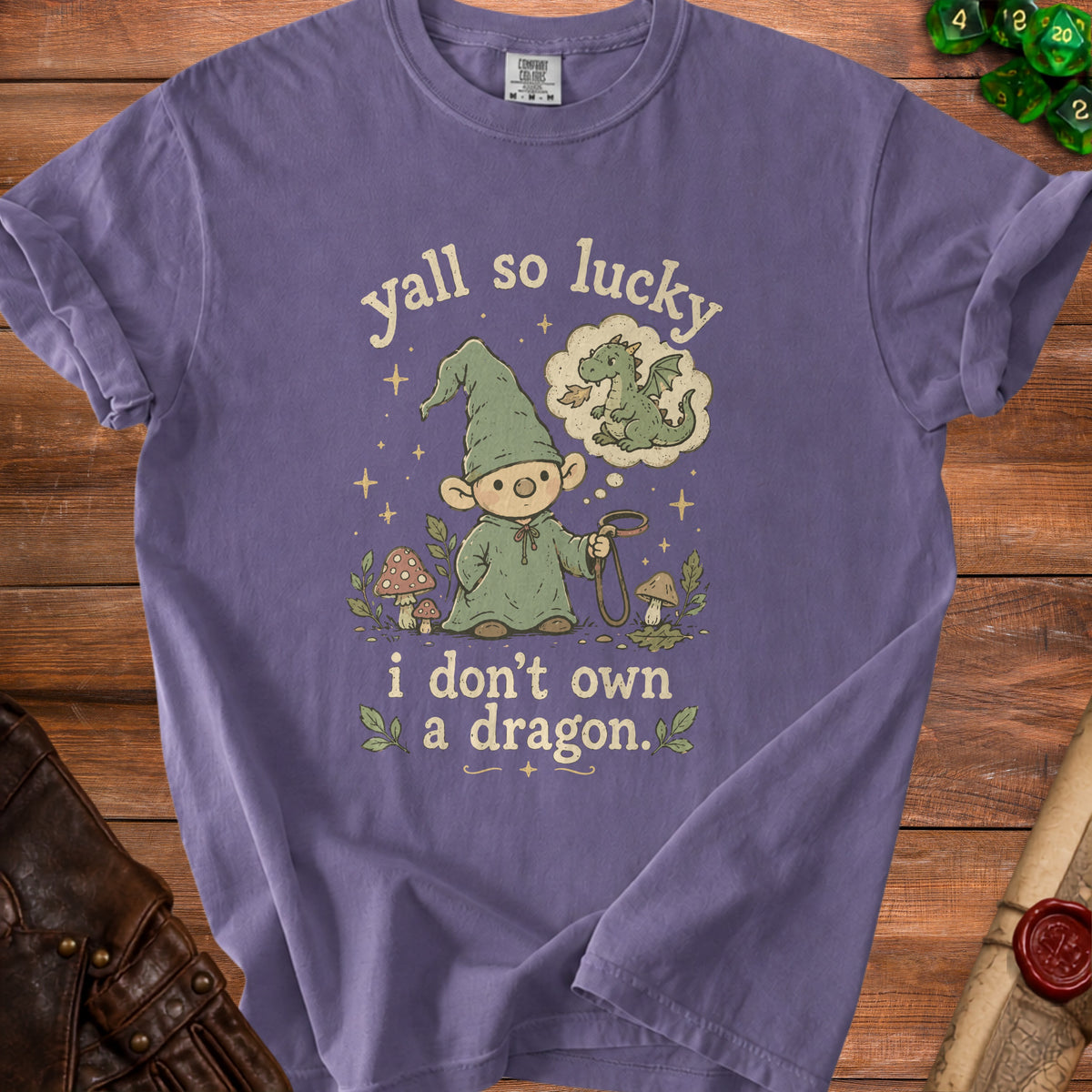 Purple t-shirt with gnome, dragon thought bubble, and text "yall so lucky i don't own a dragon."