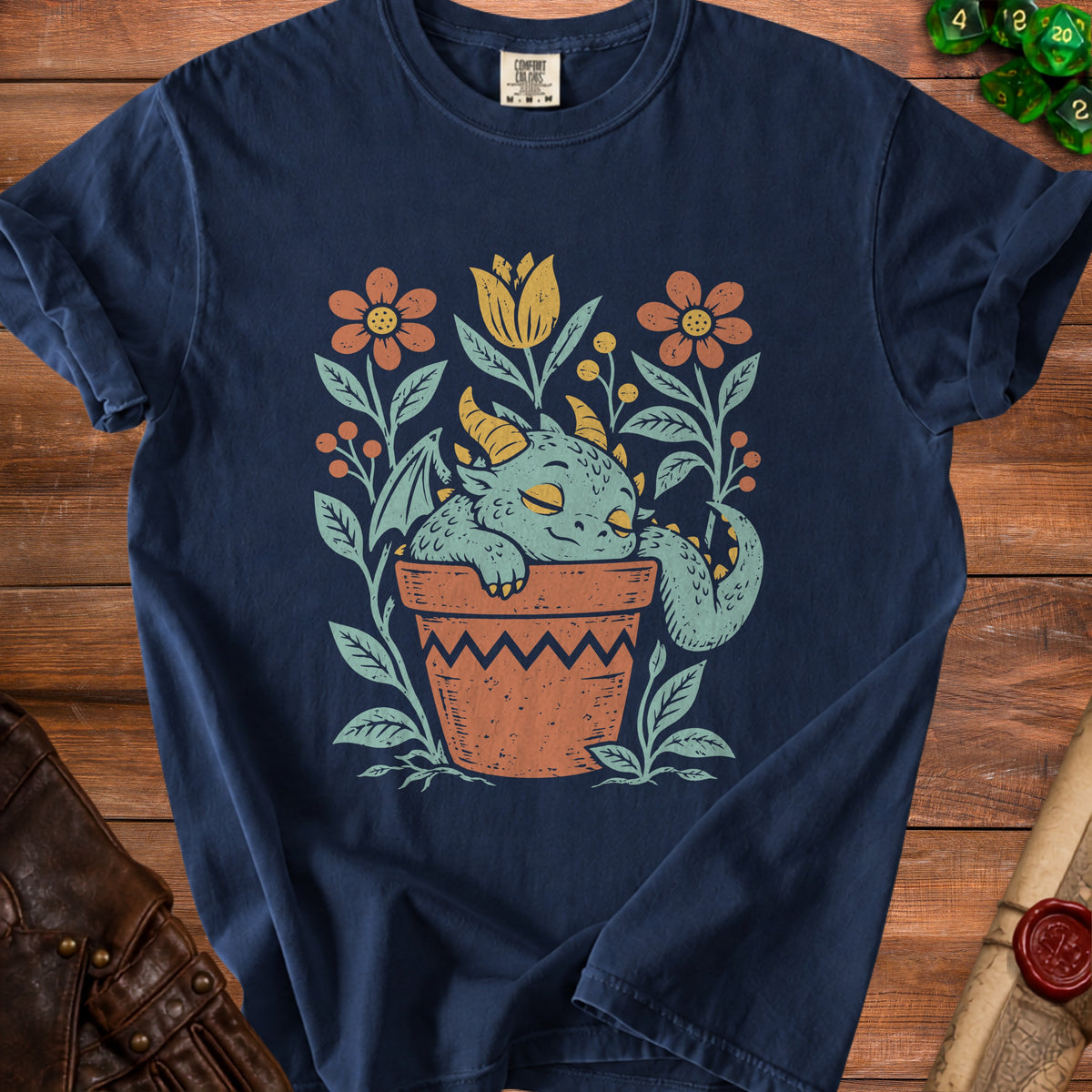 Navy t-shirt with a cute dragon sleeping in a potted plant with flowers.