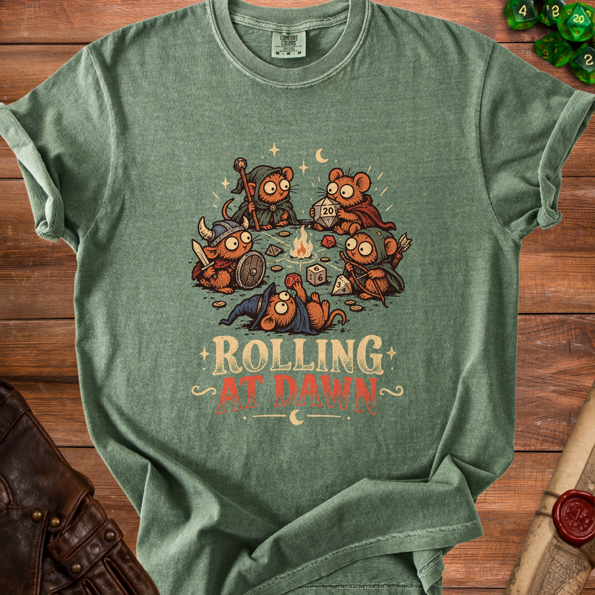Green t-shirt featuring cartoon mice playing dice and a campfire, with text "ROLLING AT DAWN".