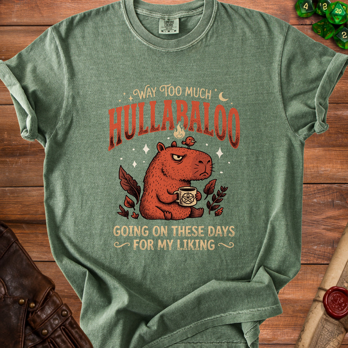 T-shirt with illustration of a capybara holding a mug and text "Way too much hullabaloo going on these days for my liking".