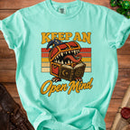 Mint t-shirt with "Keep an Open Mind" graphic featuring a monster chest reading a book.