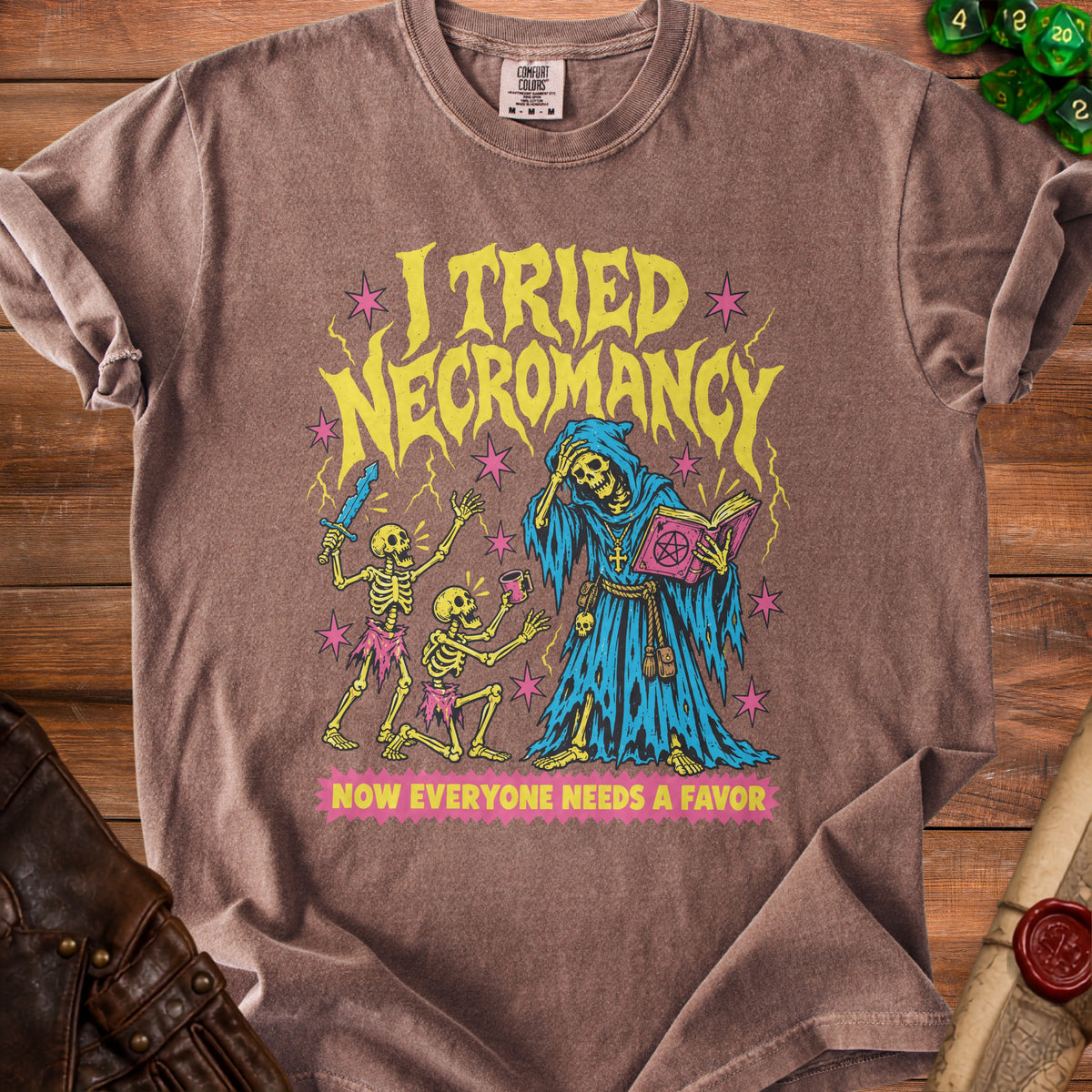 Brown t-shirt with "I tried Necromancy Now everyone needs a favor" graphic.