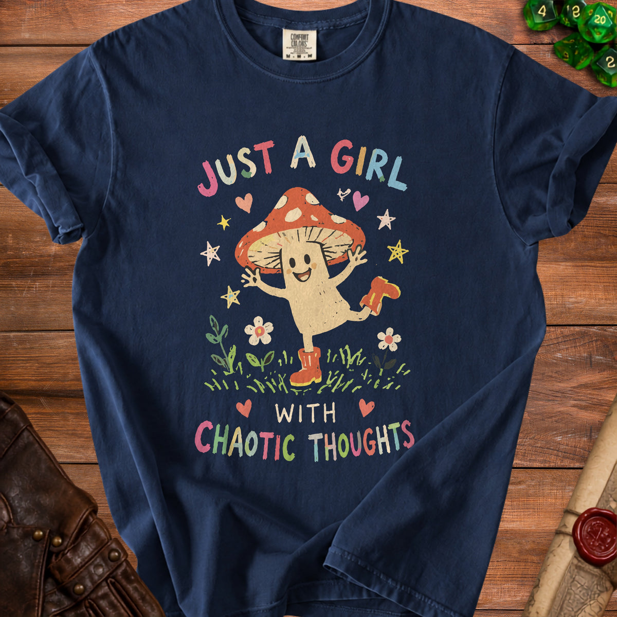 Navy blue t-shirt with a mushroom character and text "Just a girl with chaotic thoughts".