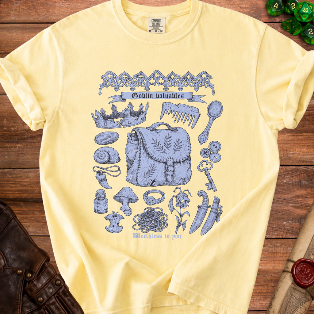 Yellow t-shirt with blue line art of a crown, bag, and various trinkets with text "Goblin valuables".