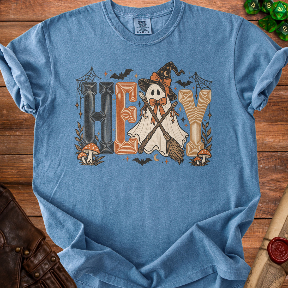 Blue t-shirt with a graphic of a ghost in a witch hat saying "HEY".