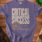 Purple t-shirt with "CRITICAL SUCCESS" text and a D20 die.