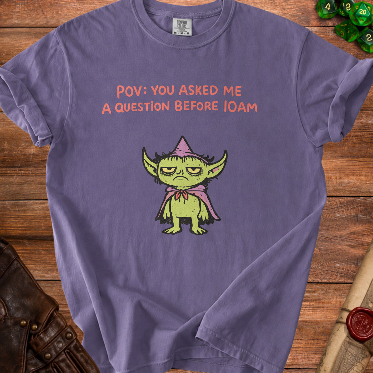 Purple t-shirt with green creature and text "POV: YOU ASKED ME A QUESTION BEFORE 10AM".