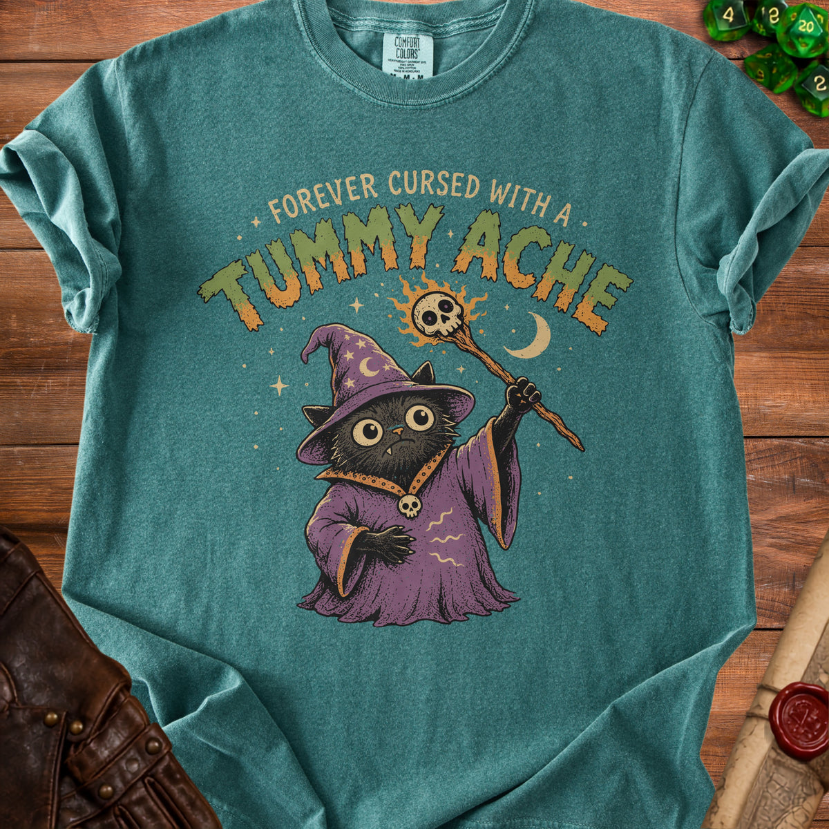 T-shirt with a black cat wizard graphic and the text "Forever Cursed With A Tummy Ache".