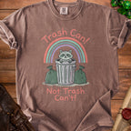 Brown t-shirt with a raccoon in a trash can, rainbow, and text "Trash Can! Not Trash Can't!".