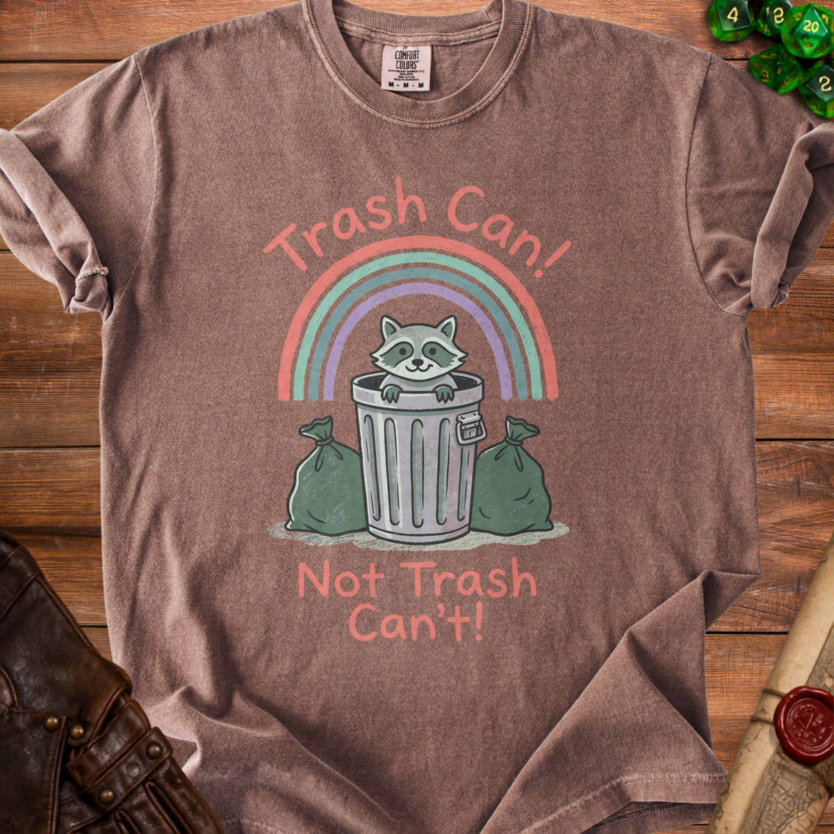 Brown t-shirt with a raccoon in a trash can, rainbow, and text "Trash Can! Not Trash Can't!".