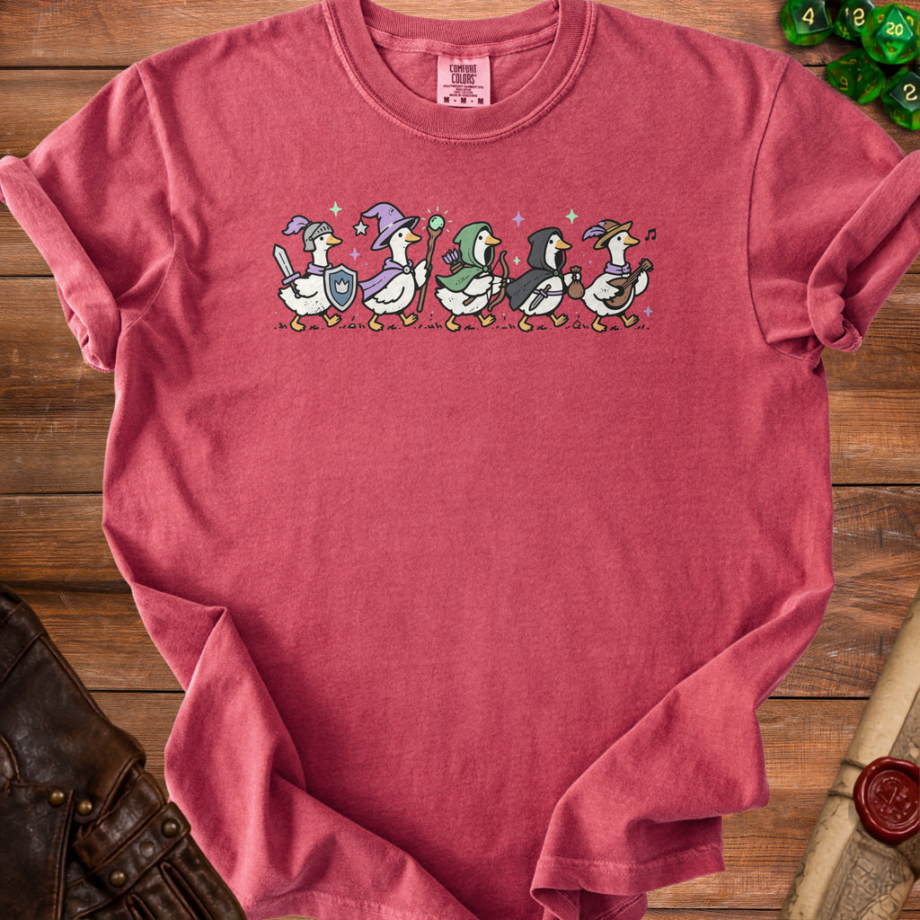 Six cartoon ducks dressed as fantasy adventurers walking in a line on a t-shirt.