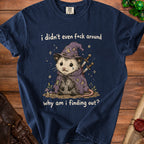 Opossum wearing a wizard hat and cape with swords, on navy t-shirt.