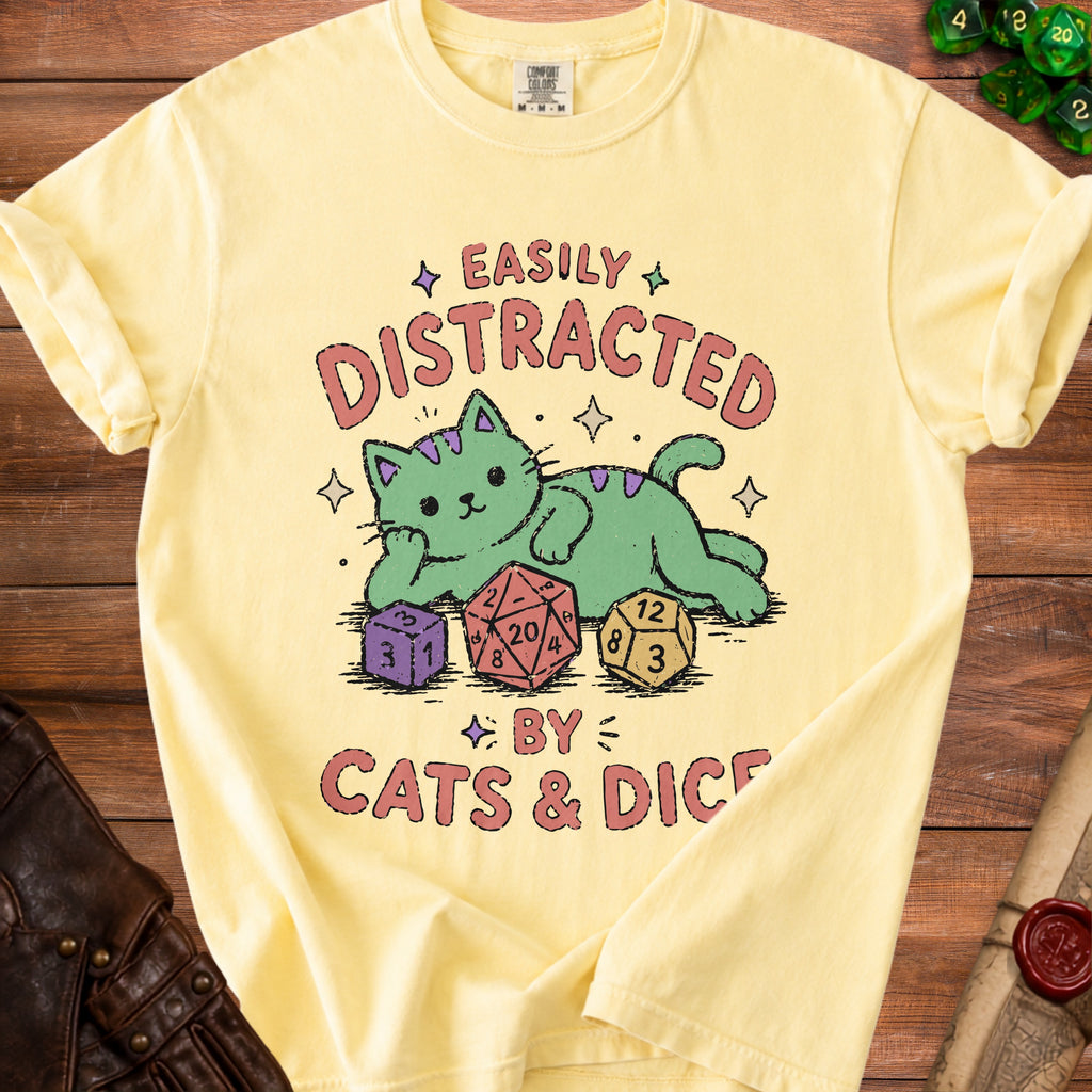 Light yellow t-shirt with "Easily Distracted By Cats & Dice" and cartoon cat illustration.
