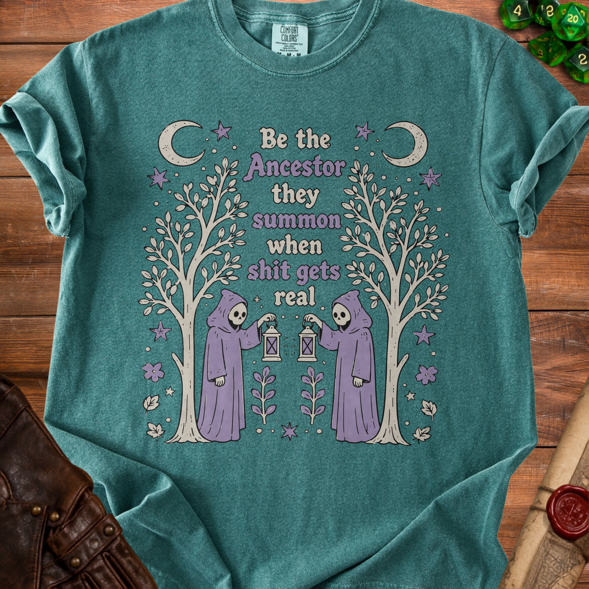 Teal t-shirt with "Be the ancestor they summon when shit gets real" text and grim reaper graphics.