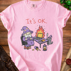 Pink t-shirt with illustration of wizard and cat at a desk with burning laptop.