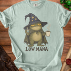 A grumpy frog wizard holds a potion and coffee with "LOW MANA" text.