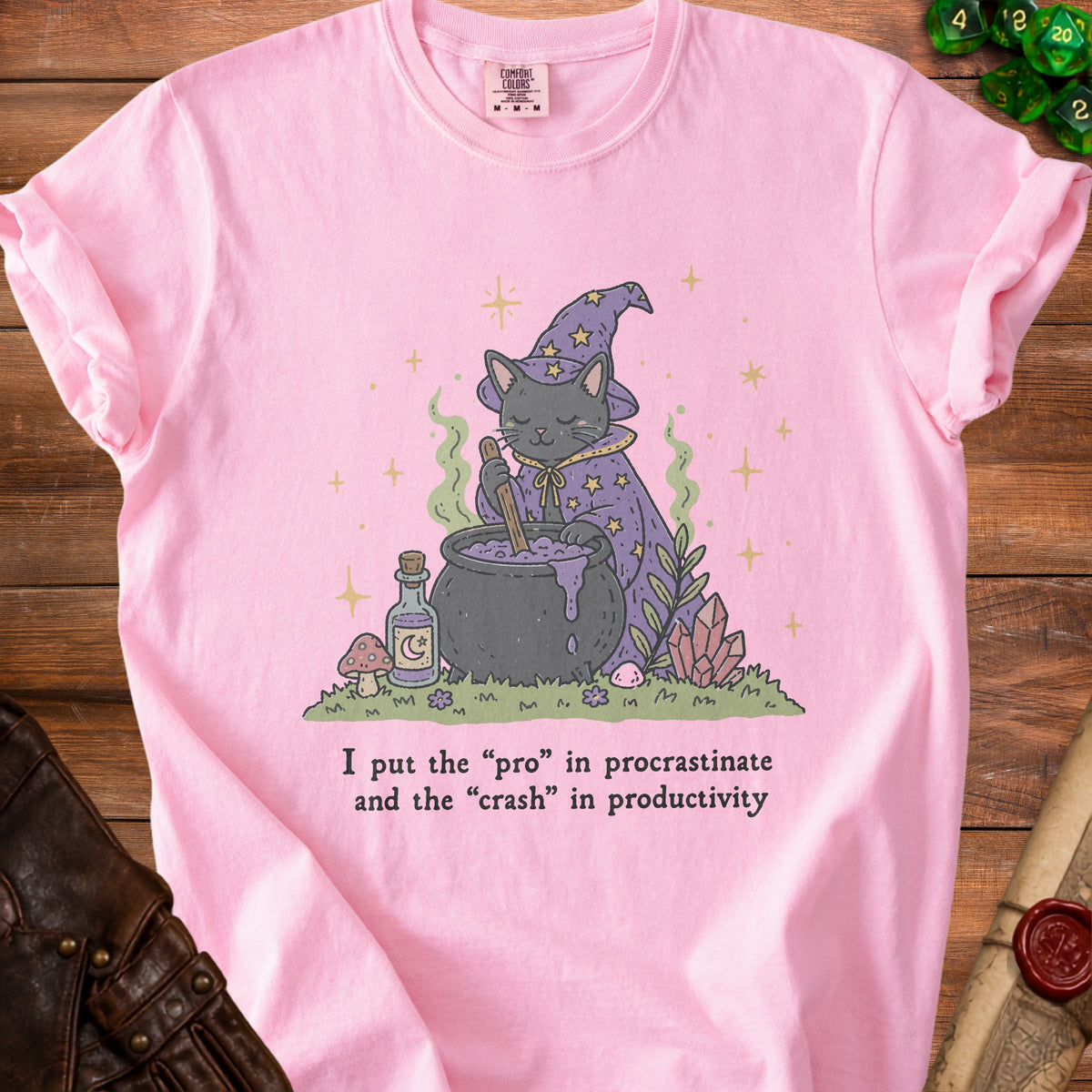 Pink t-shirt with a graphic of a cat witch and text about procrastination.