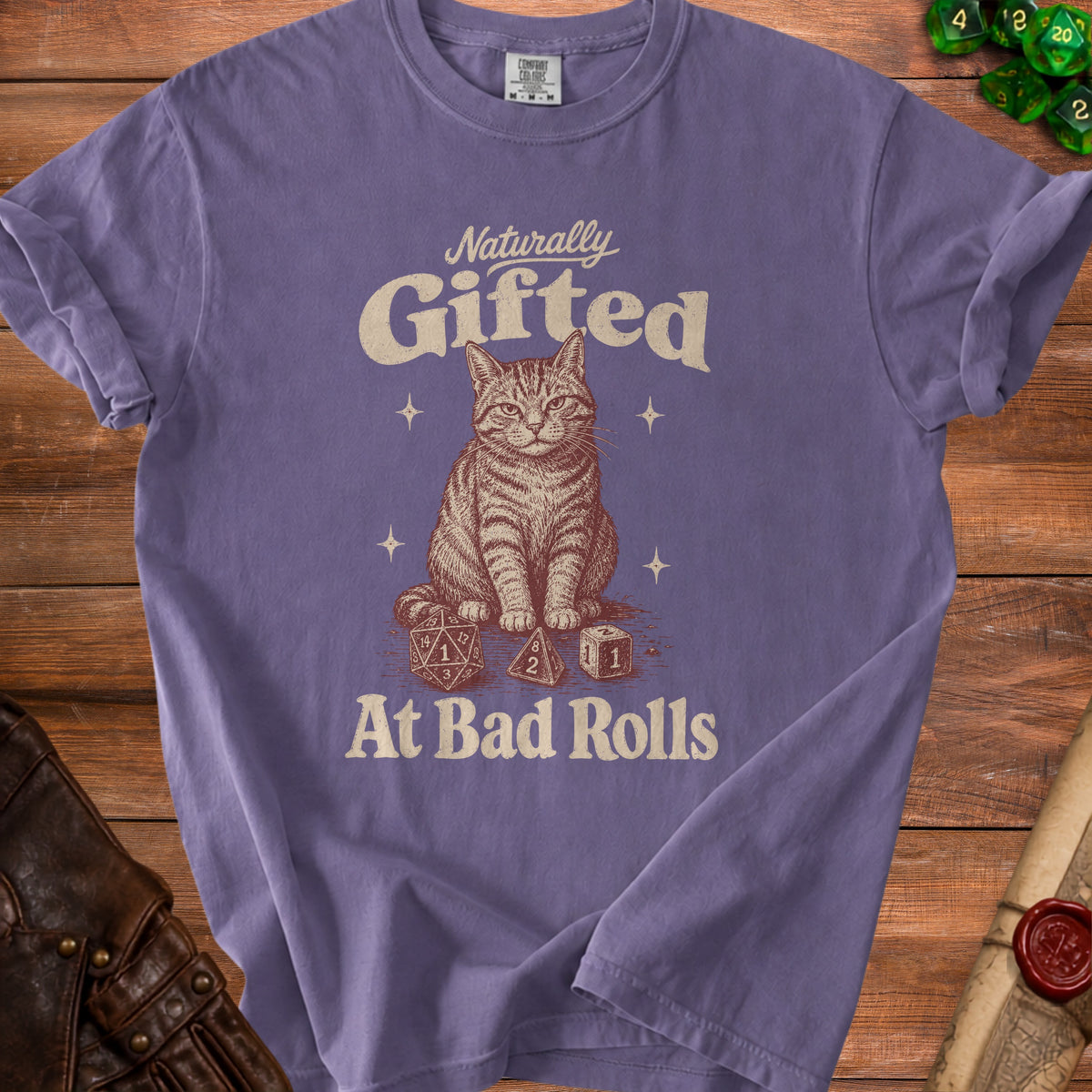 Purple t-shirt with a tabby cat and dice graphic that reads "Naturally Gifted At Bad Rolls."