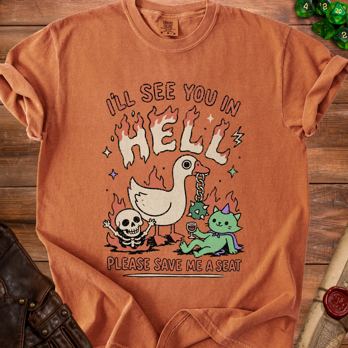 Orange t-shirt graphic with text "I'LL SEE YOU IN HELL PLEASE SAVE ME A SEAT".