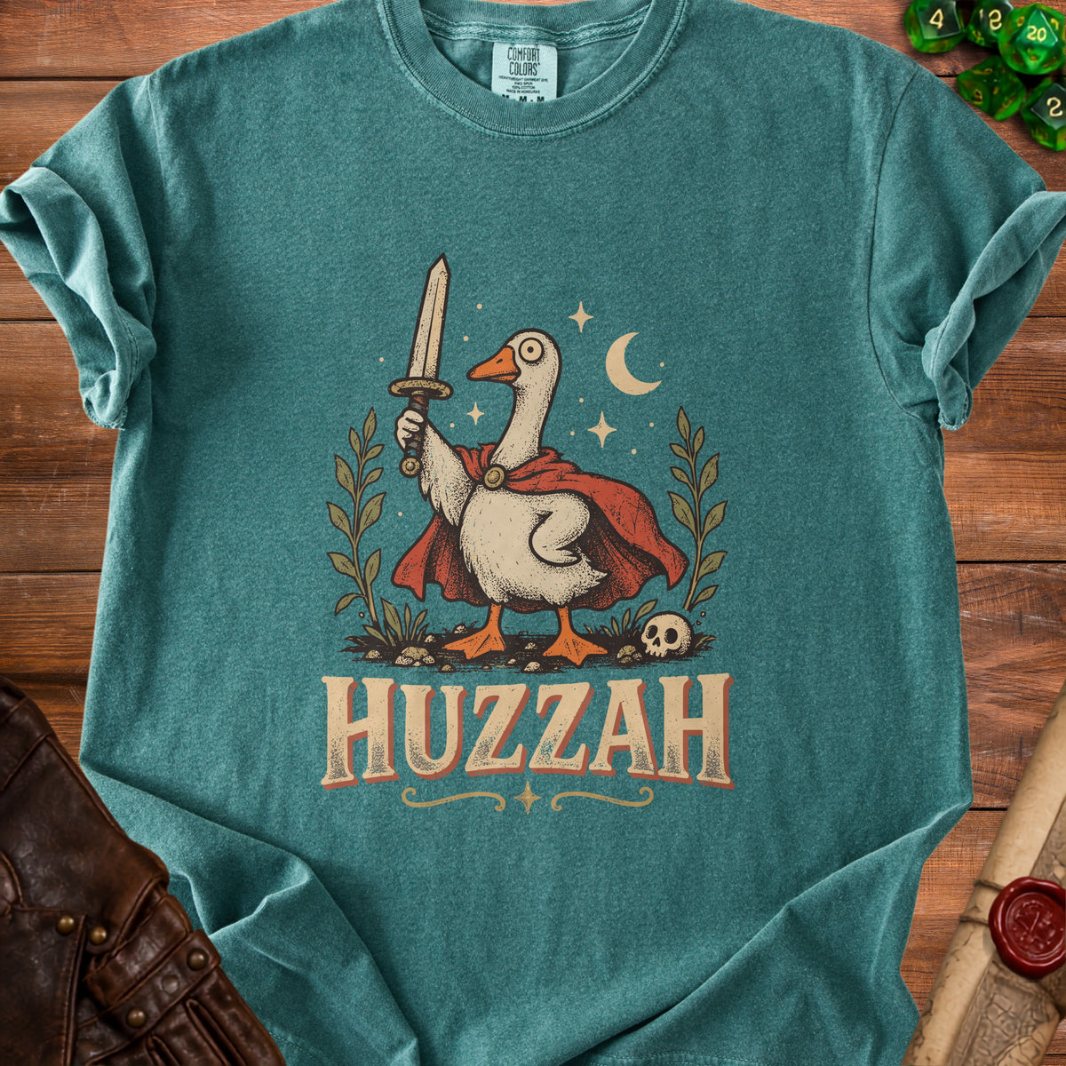 Green t-shirt with a cartoon goose holding a sword and the word "HUZZAH".