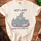 Cream t-shirt with "NOT LAZY ENERGY IS IN HUDDLE MO" and cartoon goblin graphic.