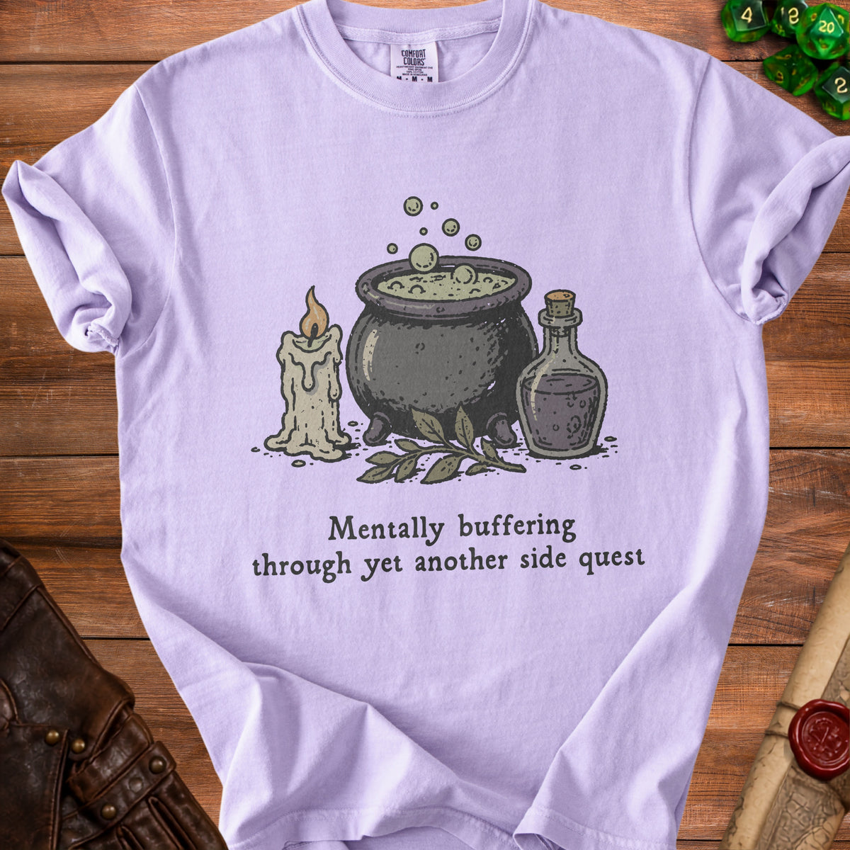 Light purple t-shirt with potion, candle, and text "Mentally buffering through yet another side quest."
