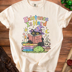 Cream t-shirt with black cat wearing wizard hat reading "But Books Help."
