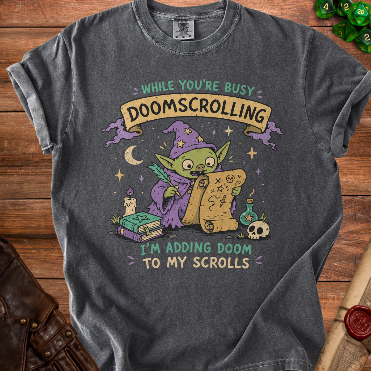 Dark gray t-shirt with green and purple goblin wizard illustration, text says "Doomscrolling" and "I'm Adding Doom to My Scrolls."