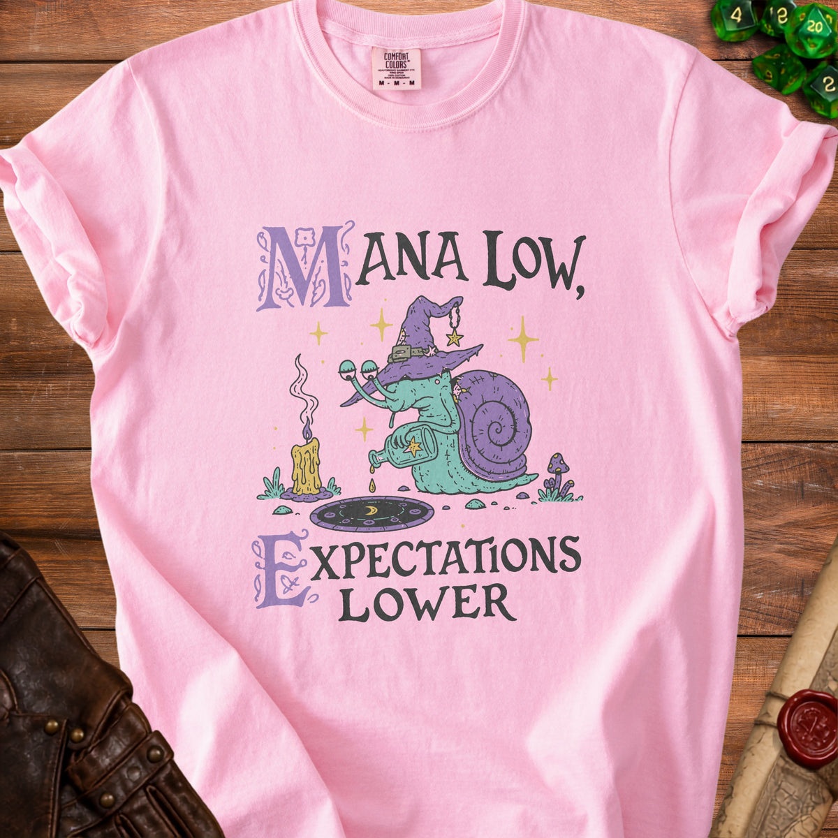 Pink t-shirt with "Mana Low, Expectations Lower" text and snail wizard graphic.