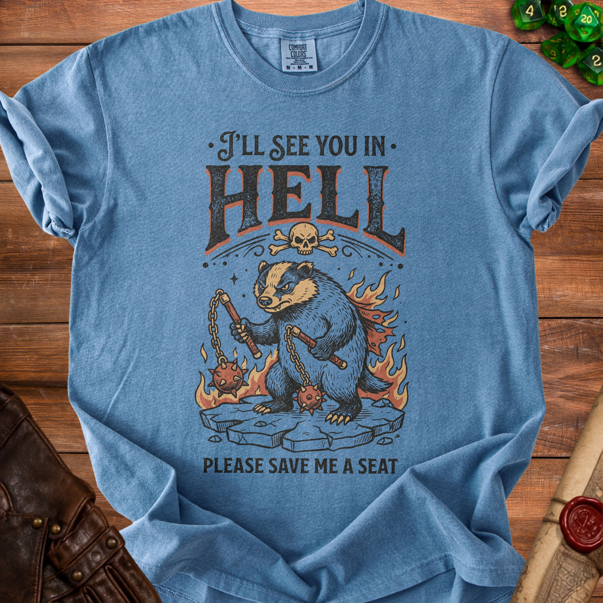 Blue t-shirt with badger in flames, holding flails, and text "I'll see you in hell".