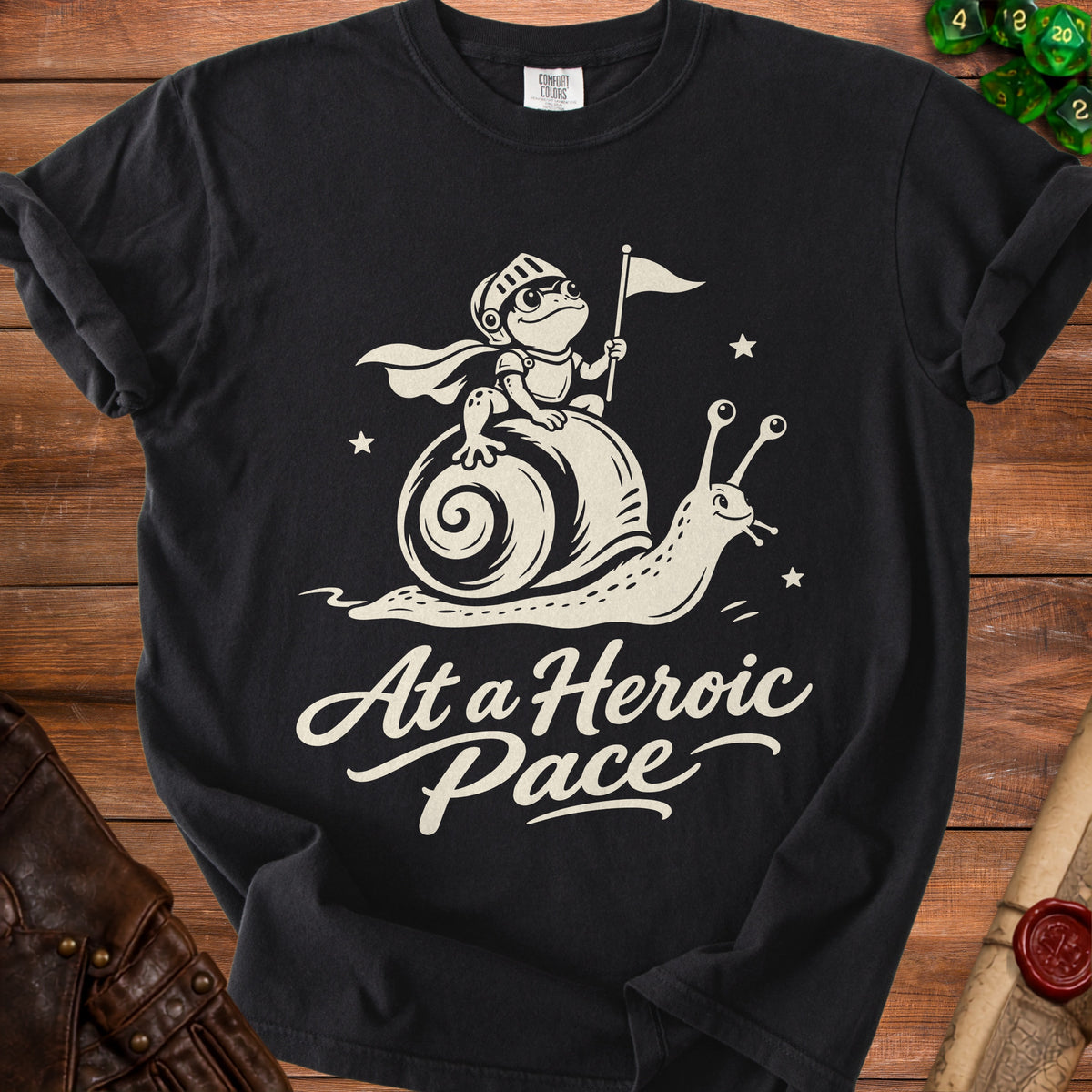 Black t-shirt with cartoon knight frog riding a snail, text "At a Heroic Pace".